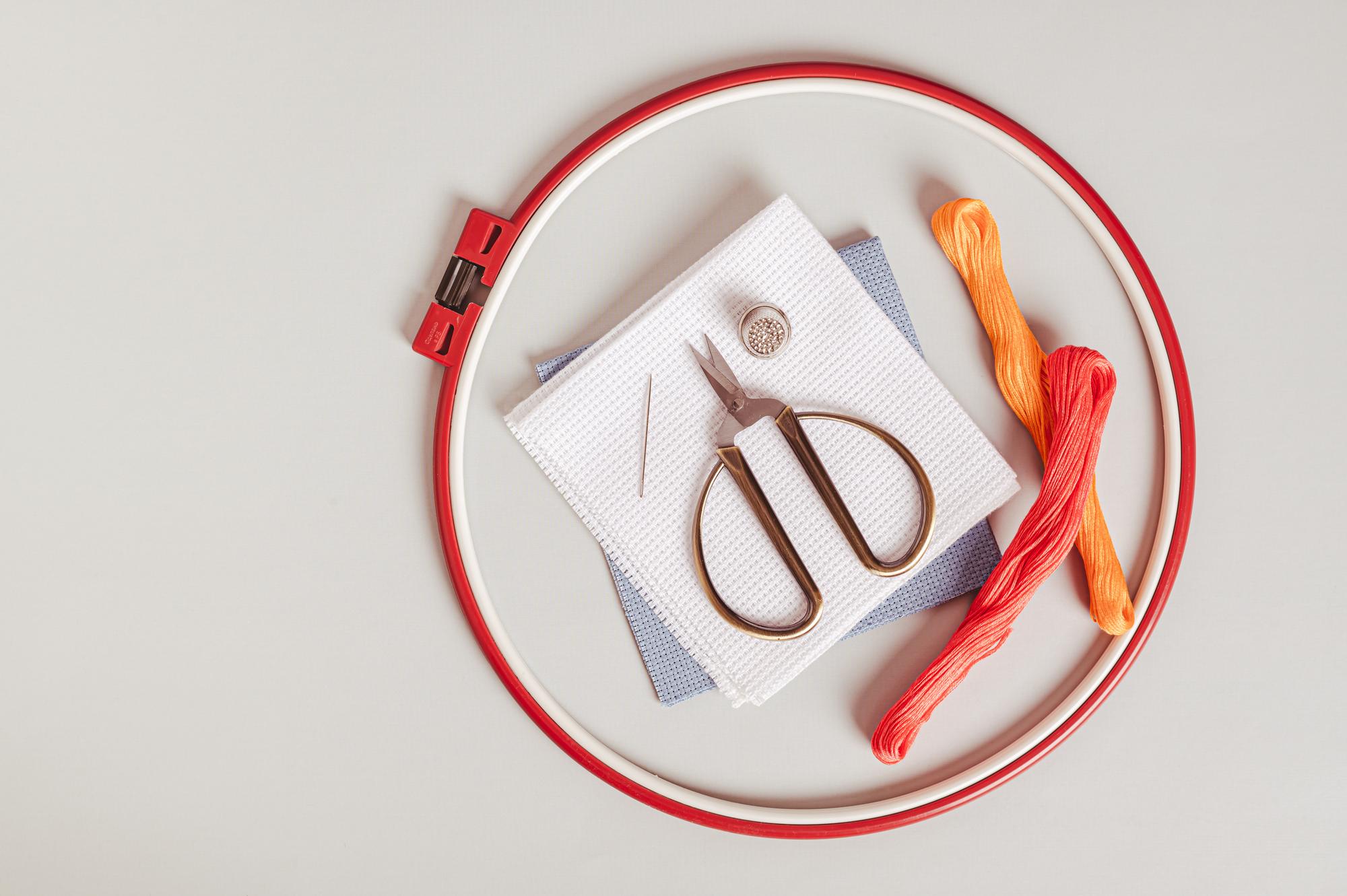 Workspace with embroidery hoop and threads